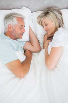 High angle view of a mature couple lying in bed at home
