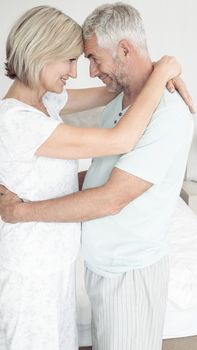 Side view of a loving mature couple with arms around at home