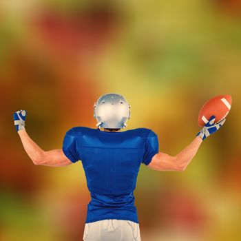 Rear view of American football player holding ball against glowing background