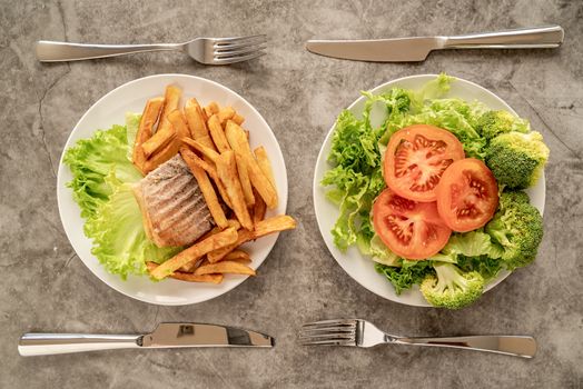 Healthy and unhealthy food concept. Plates with fast food and healthy food top view flat lay