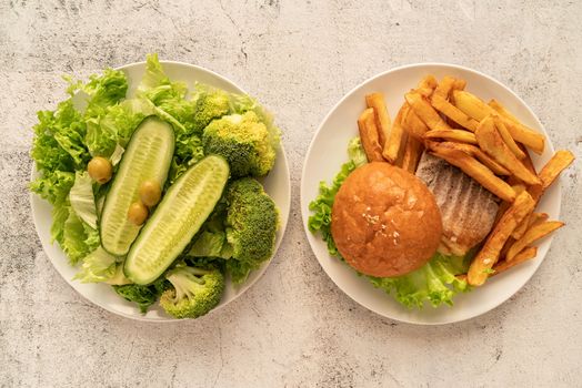 Healthy and unhealthy food concept. Plates with fast food and healthy food top view flat lay