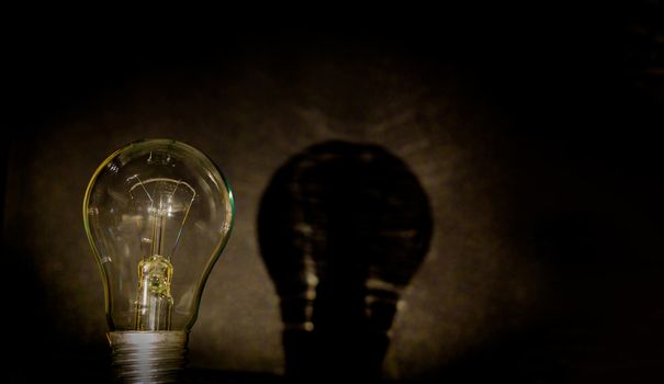 Light bulb, business idea concept. A light bulb on a black background to place text or illustration. The light bulb is a symbol of ideas, innovations, and new thoughts. 220 volt