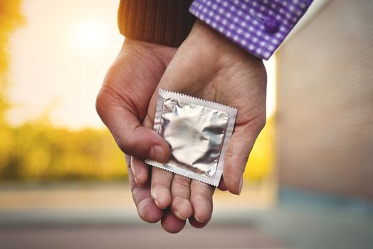 Men, women, couples Holding a condom for self-protection. Concept to prevent contraception.