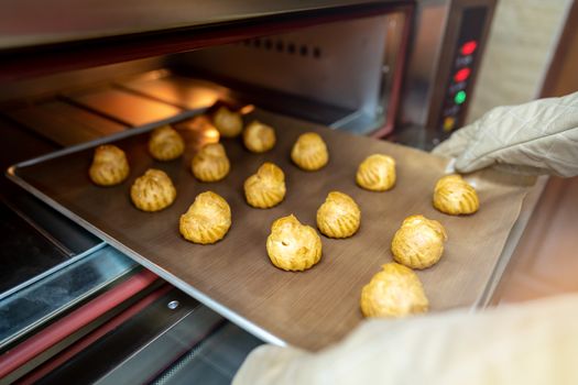 Bakery baker preparing bread cooking in the oven.Bakery close up holding a peel with freshly baked.Activity during quarantine home with family together.