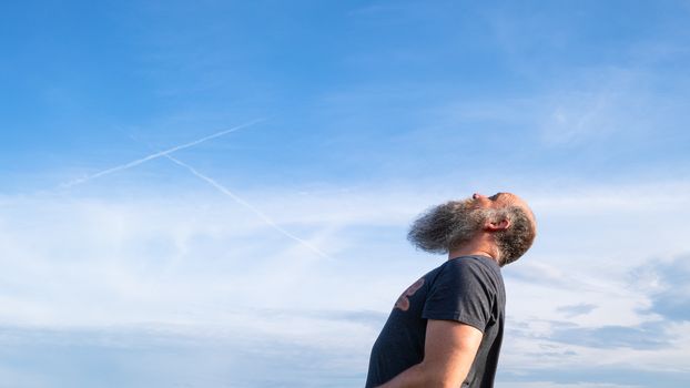 An image of a man looking up to the blue sky