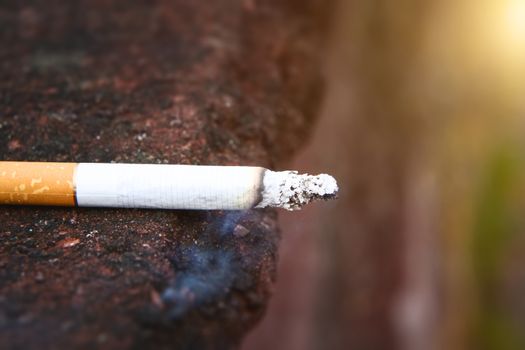 An image of a smoking cigarette side view