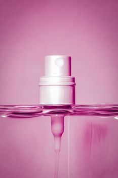 An image of a pink perfume bottle head detail