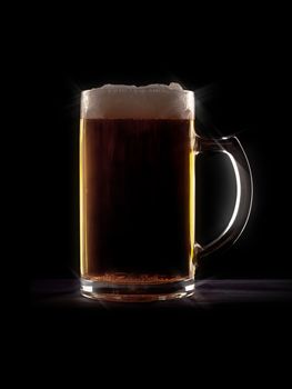 An image of a typical beer in a glass with black background