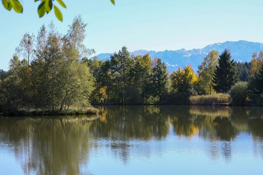 A photography of a lake and autumn trees