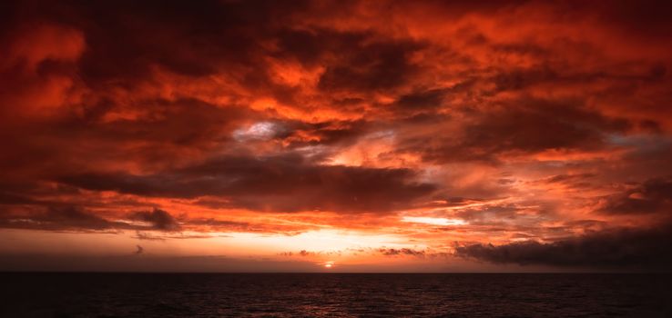 Dramatic Fiery Sunset With Orange And Red Clouds Over The Ocean