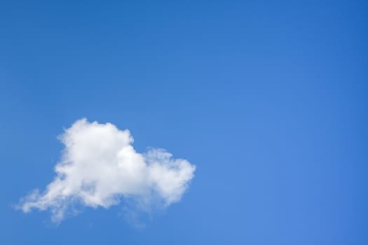 An image of a single cloud in the blue sky background