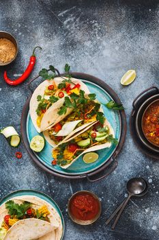 Healthy vegan tacos made with with lentils, pico de gallo sauce,  vegetables, avocado and guacamole, ready to eat. Top view, blank space