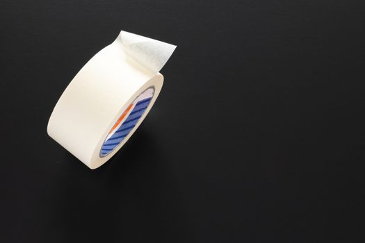 A typical painters adhesive roll isolated on black background