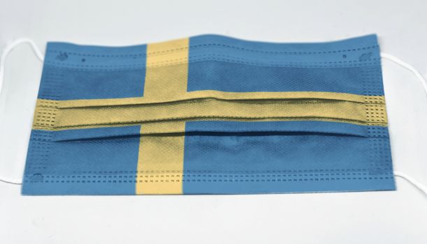 surgical mask with the national flag of Sweden printed. Pandemic covid-19 and preventive measures to counter the spread of the virus