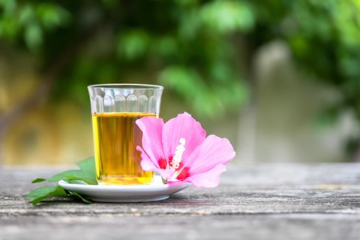 A mallow tea with blossom on old wooden background