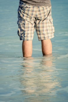 An image of a man standing in the sea water