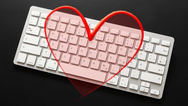 An image of a typical computer keyboard with a red heart overlay