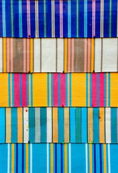 Abstract and vibrant colourful fabric backdrop. Fabric pinned to board in bright colours with cultural and ethnic patterns.