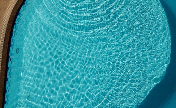 Swimming pool blue color clear water and people enjoying in summer sunny day and top view angle.