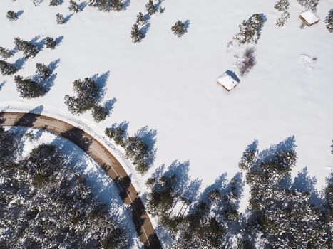 Snowy Mountain Landscape. Aerial view of a forest and road under the snow, copy space