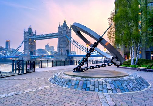 London, United Kingdom - April 17, 2019 : View of Tower Bridge on the River Thames with the sundial, titled Timepiece, that was designed by Wendy Taylor in 1973.