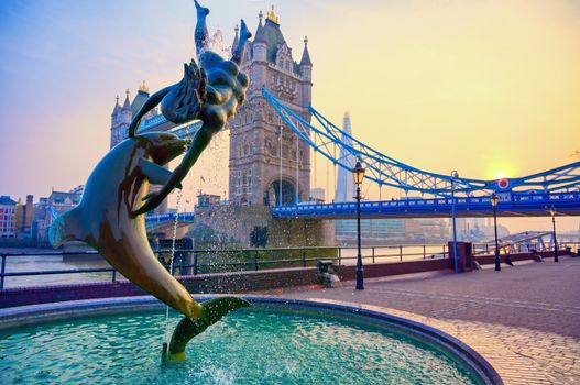 London, United Kingdom - April 17, 2019 : View of Tower Bridge on the River Thames with the Girl with Dolphin fountain, created by David Wynne in 1973.