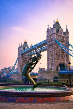 London, United Kingdom - April 17, 2019 : View of Tower Bridge on the River Thames with the Girl with Dolphin fountain, created by David Wynne in 1973.