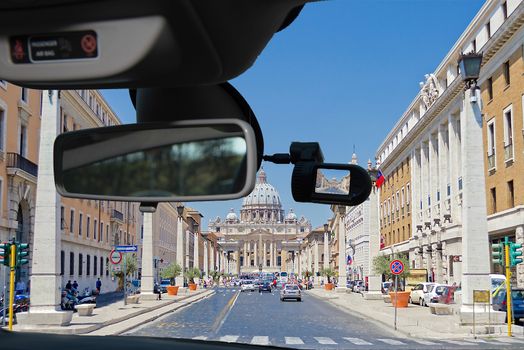 Looking through a dashcam car camera installed on a windshield with view of Via della Conciliazione leading to Saint Peter's Church, Rome, Italy