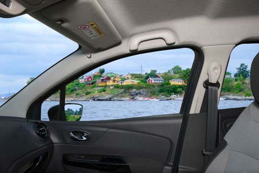 Looking through a car window with view over colorful houses on the shore of Oslo fjord, Oslo, Norway