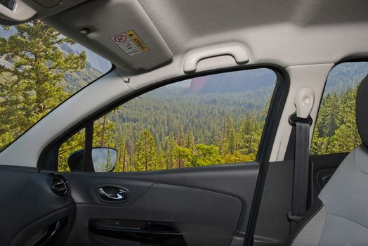 Looking through a car window with view of a beautiful green valley in Yosemite National Park, USA