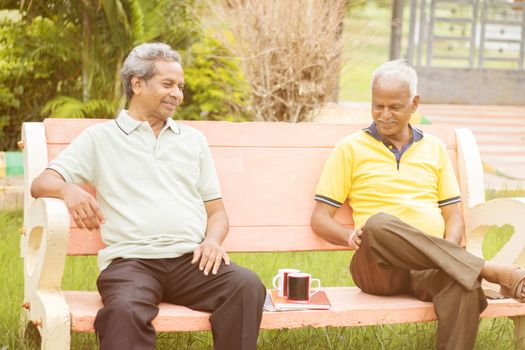 Active retired old men and leisure concept - two senior friends talking outdoor during evening time with coffee - Two elderly brothers having happy time