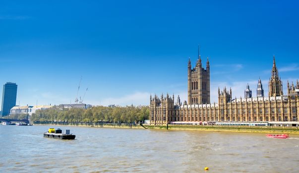 British Parliament along the River Thames on a sunny day in London, UK.