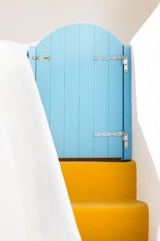 Small blue greek door and yellow steps on Santorini island, Greece