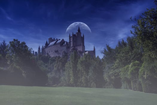 Alcazar de Segovia, old medieval palace in Segovia, Spain. Night shot in the blue hour with moon.