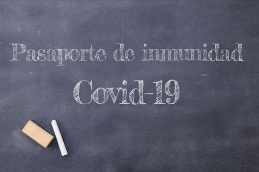 Covid-19 immunity passport written in Spanish on a blackboard.