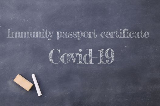 Immunity passport certificate Covid-19 written on a blackboard.