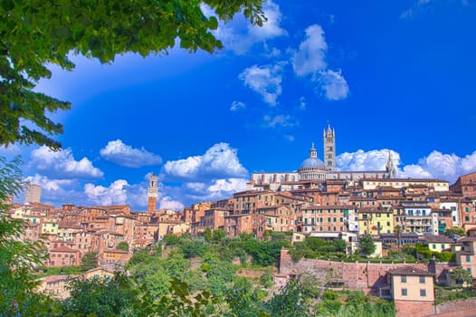 Beautiful panoramic view of the historic city of Siena at sunset with an amazing cloudscape on an idyllic summer evening, Tuscany, Italy