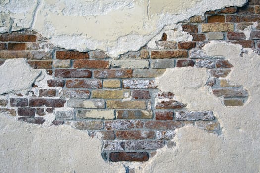 Old brick wall with peeling plaster, grunge background.