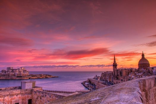 View from above of the golden dome of church and roofs with church of Our Lady of Mount Carmel and St. Paul's Cathedral in Valletta, Malta.