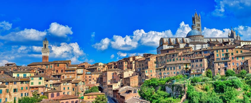 Beautiful panoramic view of the historic city of Siena at sunset with an amazing cloudscape on an idyllic summer evening, Tuscany, Italy