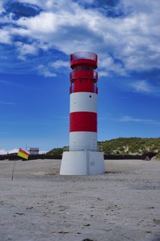 The red and white small Lighthouse on Island Dune - Heligoland - Germany with blue Sky