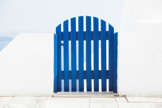Blue wooden gate in front of the sea,Greece, Santorini, Oia,