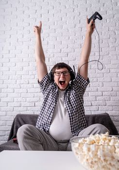 Stay home. Excited young man playing video games at home enjoying his victory