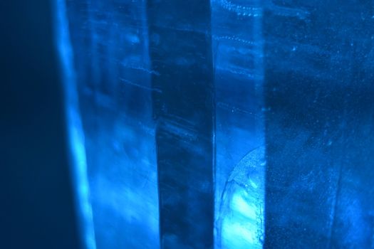 Bubbles are trapped within these columns of blue ice that swim in and out of focus to give a monochromatic background texture photograph, noise reduced.