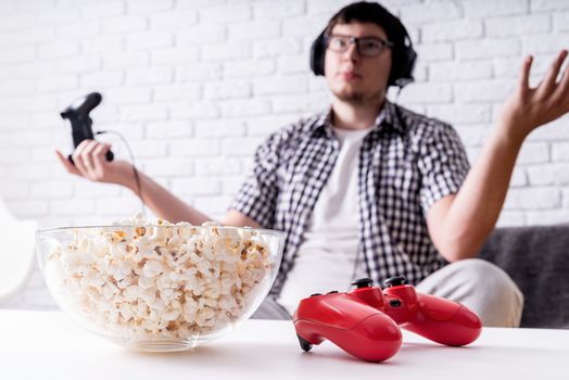 Stay home. Disappointed young man playing video games at home. Selective focus