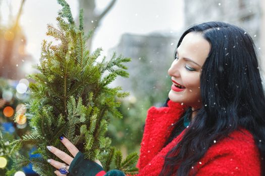 Woman selecting Christmas tree at Christmas tree farm. Holiday shoppers on a traditional Christmas market. Selective focus, copy space