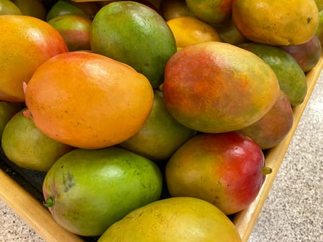 Mangos in a bin at a grocery store.
