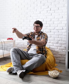 Stay home. Funny surprised young man playing video games at home