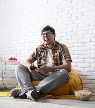 Stay home. Excited young man playing video games at home and laughing