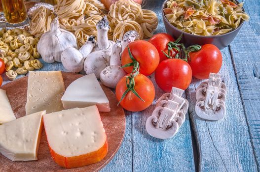 Italian cuisine with a set of ingredients for cooking pasta on a wooden surface.